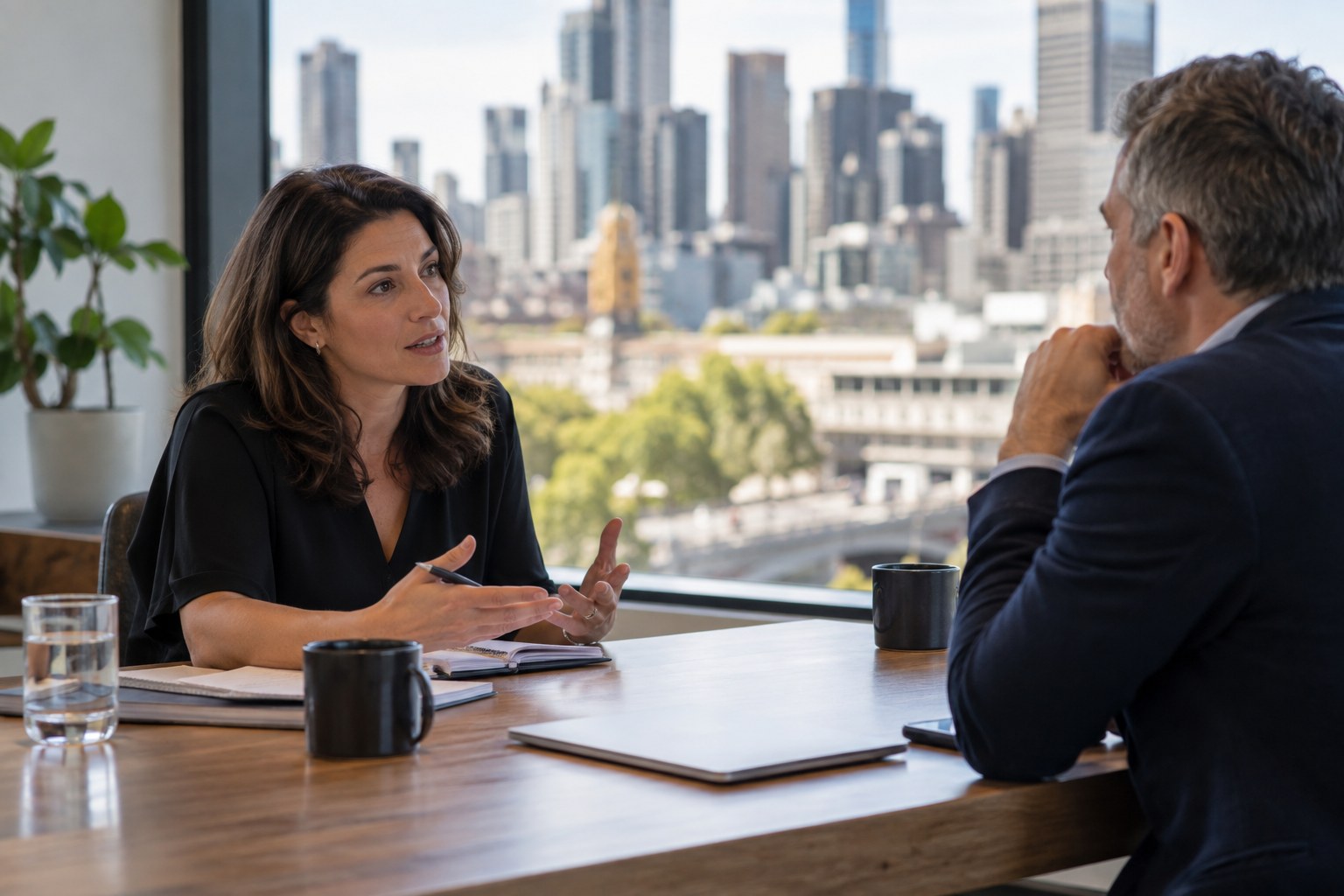 Business owner and consultant discuss a proposal at a meeting table.