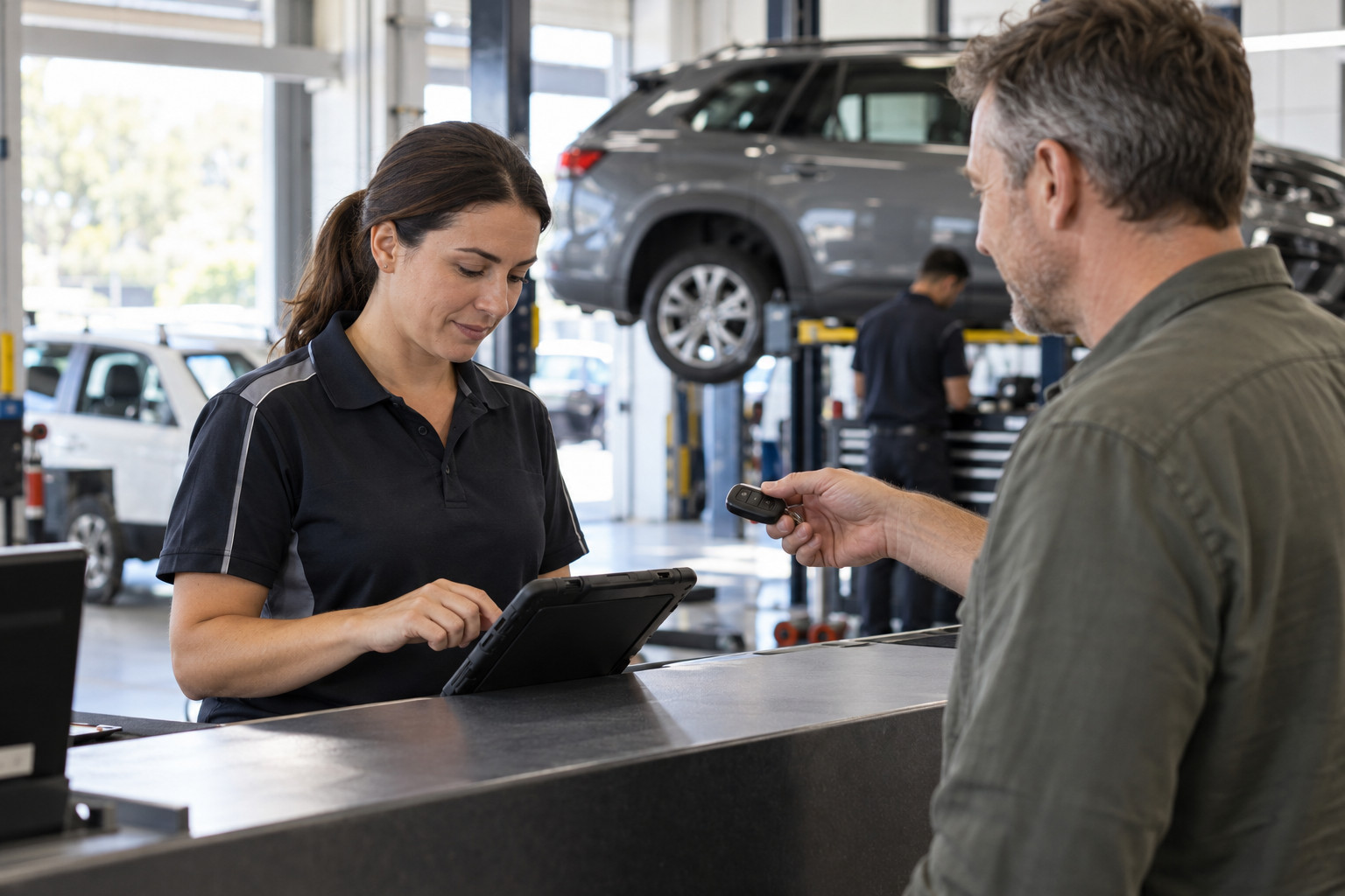 Service adviser discusses a booking with a customer at the workshop counter.